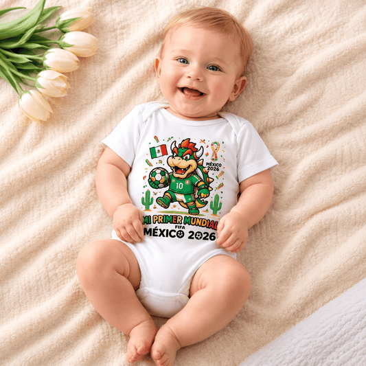 Baby wearing a "Mi Primer Mundial México 2026" football-themed onesie, smiling on a soft cream blanket. Perfect personalised baby bodysuit for World Cup fans and keepsake photos.