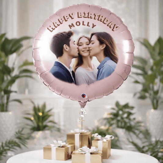 Personalized birthday balloon with a photo of a girl with her parents and 'Happy Birthday Molly' text, placed on a table with gifts and plants.