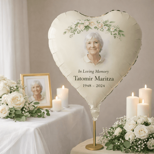 Personalised Heart-shaped balloon with a photo of an elderly woman and memorial text, surrounded by flowers and candles on a table.